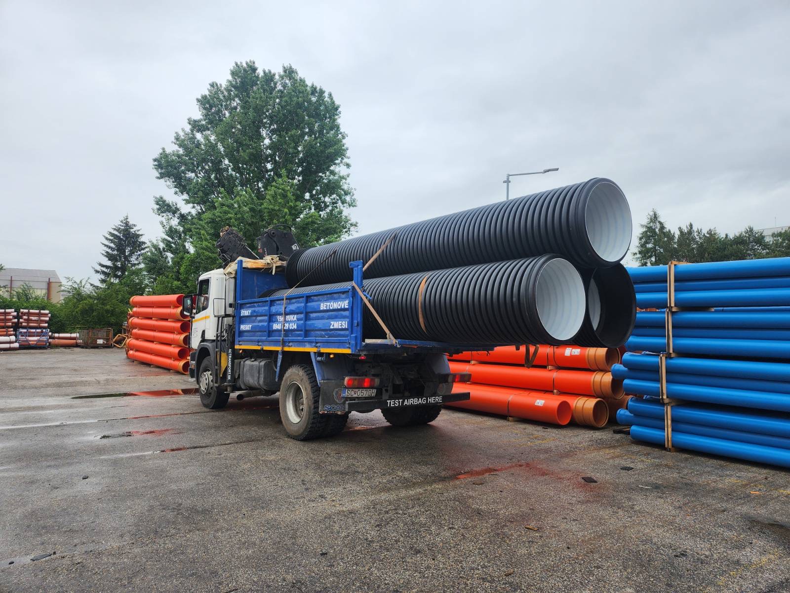Truck carrying high-volume pipes and construction material.